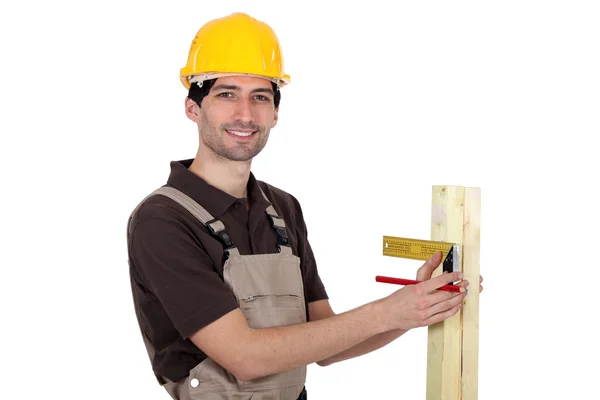 Retrato de jovem carpinteiro fazendo medições — Fotografia de Stock