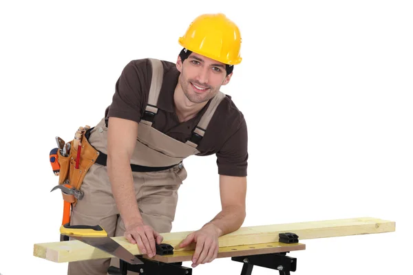 Carpenter sawing a plank — Stock Photo, Image