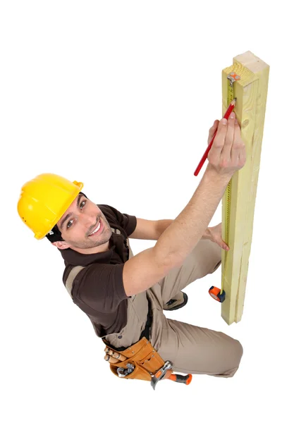 Hantverkare mäta en planka — Stockfoto