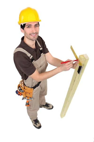 Carpinter measuring plank of wood — Stock Photo, Image