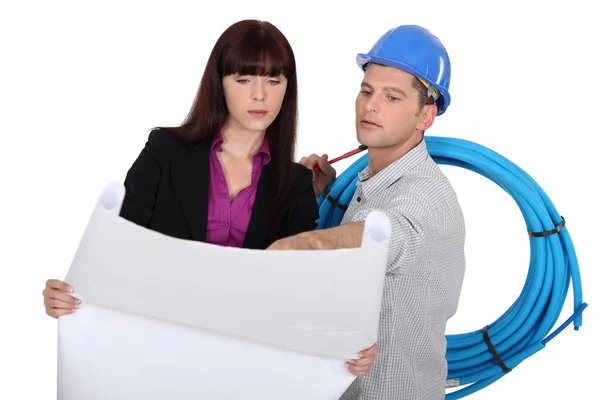 Construction worker and an engineer looking at a drawing — Stock Photo, Image