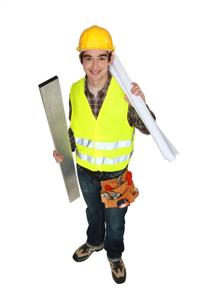 Retrato de un joven carpintero sosteniendo poste de acero y planos aislados en blanco —  Fotos de Stock