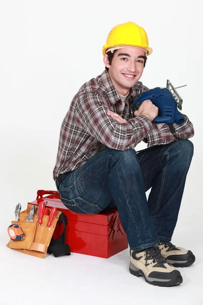 Jovem artesão sentado na caixa de ferramentas — Fotografia de Stock