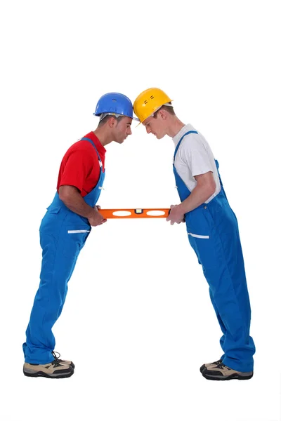 Two craftsmen holding a level — Stock Photo, Image
