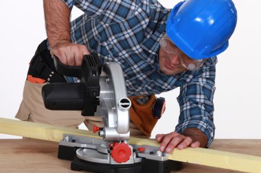 Tradesman using a mitre saw clipart