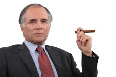 A mature businessman smoking a cigar. clipart