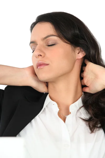 Businesswoman rubbing her neck — Stockfoto