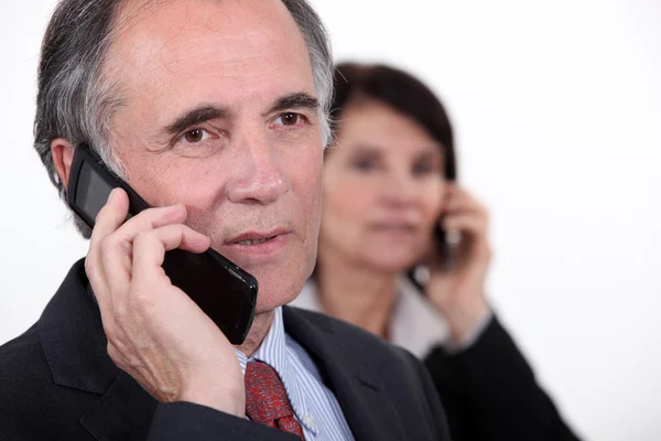 Two businesspeople making phone calls — Stock Photo, Image