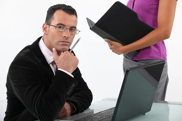 Empresário olhando sério com secretário ao seu lado — Fotografia de Stock