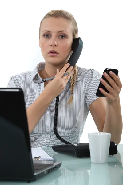 Ofis çalışanı ile iki telefon — Stok fotoğraf
