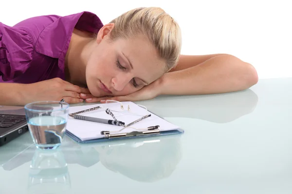 Женщина-офисный работник спит за столом — стоковое фото