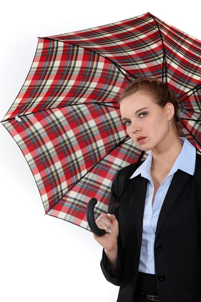 Молодая женщина в костюме с зонтиком — стоковое фото
