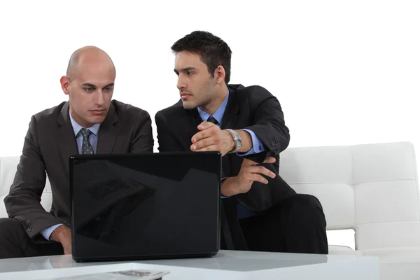 Seriöse Geschäftsleute mit Laptop — Stockfoto