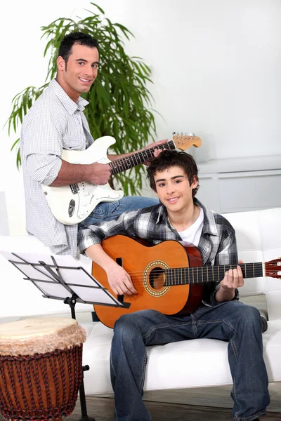 Pai ensinando filho como tocar guitarra — Fotografia de Stock