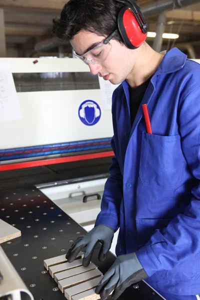 Trabajador joven de fábrica que prepara la máquina — Foto de Stock