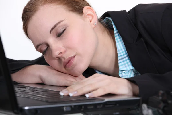 Eine Geschäftsfrau schläft auf ihrem Laptop. — Stockfoto