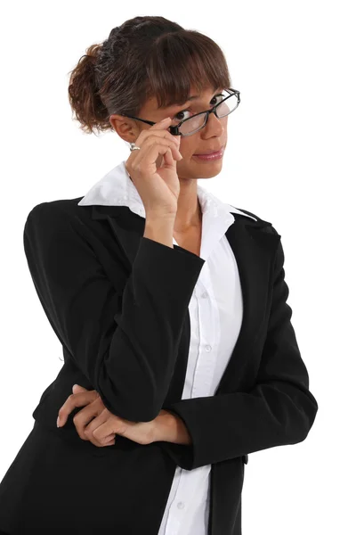 Businesswoman peering over her glasses Royalty Free Stock Photos