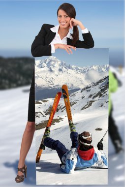 Businesswoman at ski leaning on picture of herself printed on canvas clipart