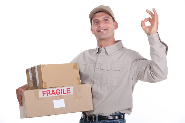 Zusteller hält Pakete und macht das Okay-Zeichen — Stockfoto