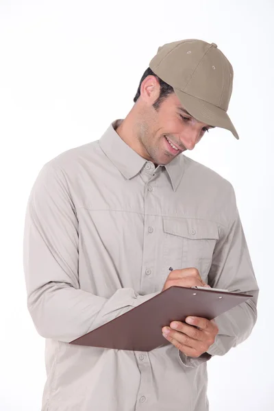 Delivery worker checking clipboard — Stock Photo, Image