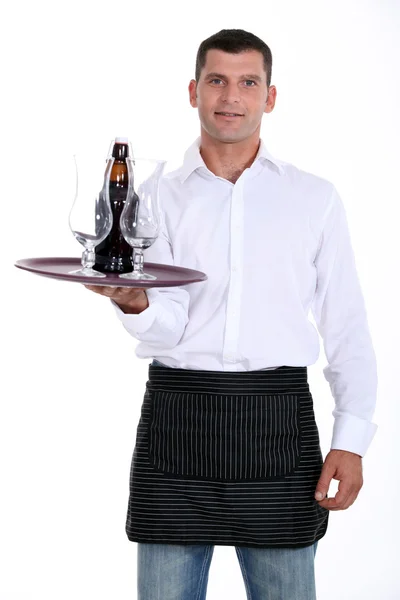Kelner Trzymając zasobnik z okulary i butelki — Zdjęcie stockowe
