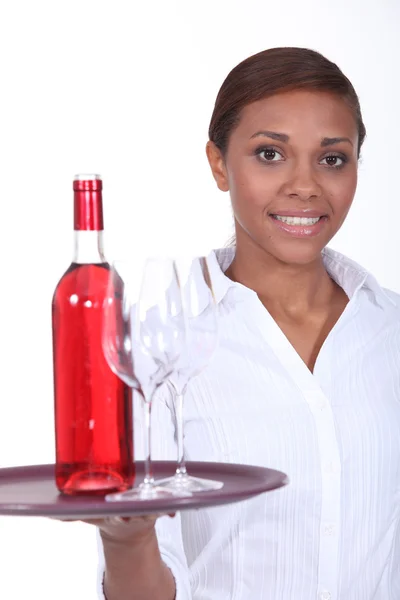 Garçonete com uma garrafa de vinho rosa — Fotografia de Stock