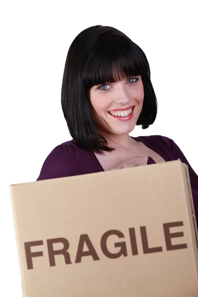 Женщина с коробкой, помеченной как хрупкая — стоковое фото