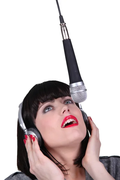 Mulher cantando em um microfone — Fotografia de Stock