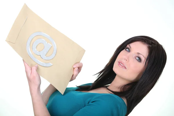 Жінка тримає конверт зі знаком на ньому — стокове фото