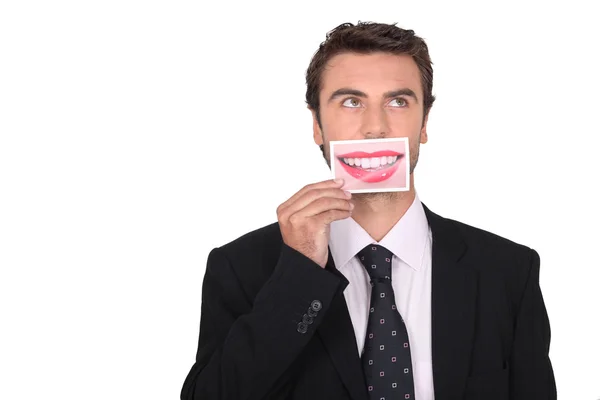 Mann im Anzug hält ein Foto von Lippen vor den Mund — Stockfoto