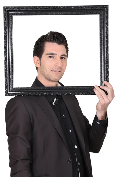 Young man holding a black frame — Stock Photo, Image