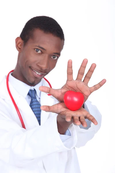 Doutor segurando um coração de plástico em suas mãos — Fotografia de Stock