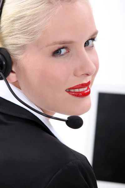 Szőke nő ült, számítógép, telefon, head-set visel — Stock Fotó