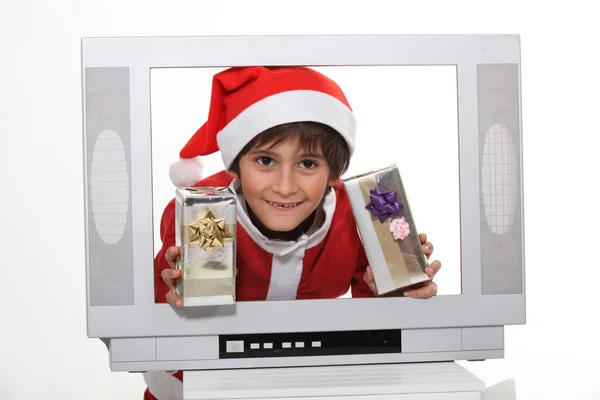 Liten pojke i jul klänning bakom TV-skärmen — Stockfoto