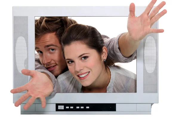 Couple popping out the TV. — Stock Photo, Image