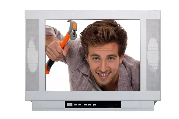 Concept image of a man hammering inside a television — Stock Photo, Image