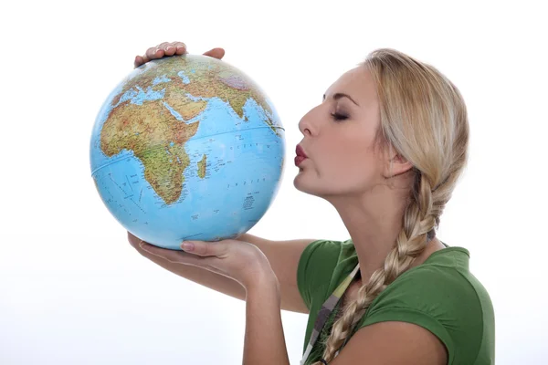 Woman in a green top kissing a globe — Stock Photo, Image