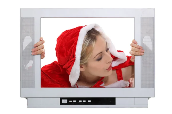 Γυναίκα σε santa claus κοστούμι αναζητούν μέσα από ένα πλαίσιο τηλεόραση — Φωτογραφία Αρχείου
