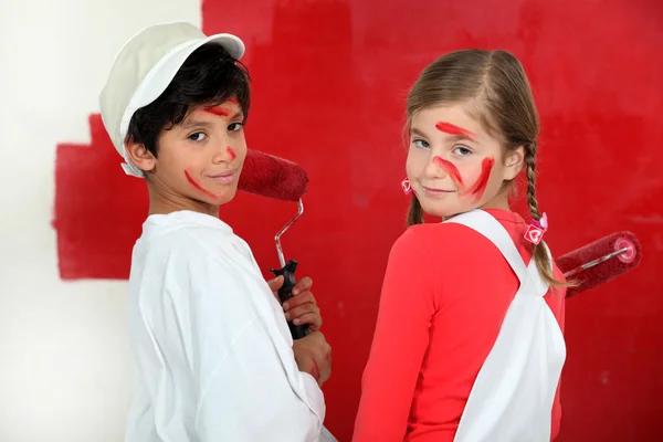 Niños pintando una pared roja — Foto de Stock