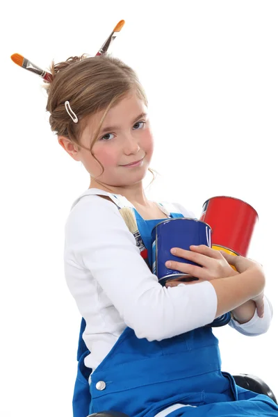 Little girl in dungarees with paint cans — Stock Photo, Image