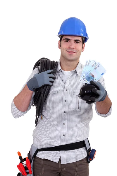 Electrician holding piggy-bank — Stock Photo, Image