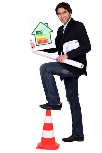 Engineer holding an energy efficiency rating chart and a rolled up drawing — Stock Photo, Image