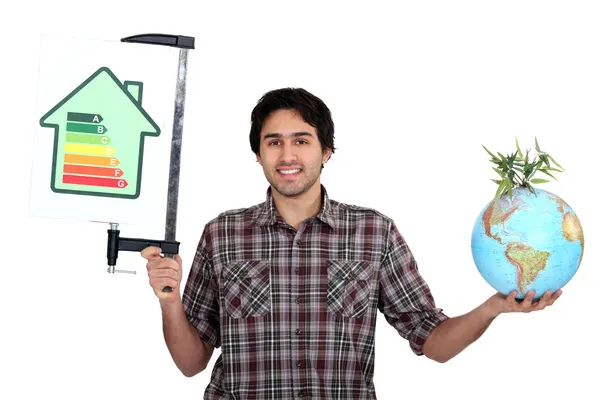 Homem segurando um globo e um gráfico de classificação de eficiência energética — Fotografia de Stock