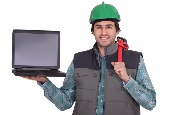 Um trabalhador manual segurando um laptop — Fotografia de Stock