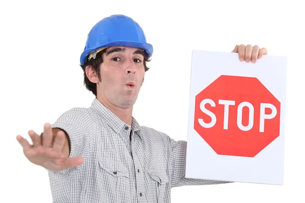 Worker holding a red stop sign — Stock Photo, Image