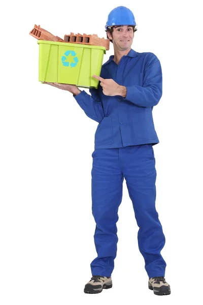 Eager tradesman pointing to a recycling bin — Stock Photo, Image