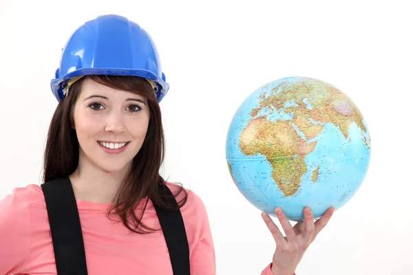 Vrouwelijke bouwer bedrijf globe — Stockfoto