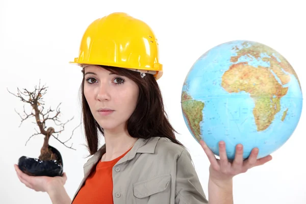 Woman holding a dead bonsai and a globe — Stock Photo, Image