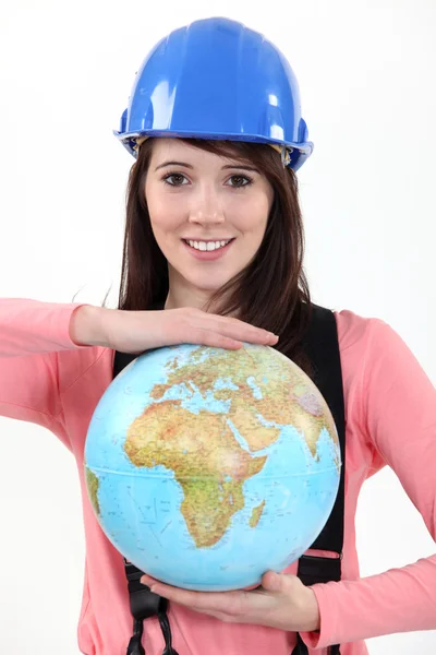 Female construction worker with a globe — Stock Photo, Image