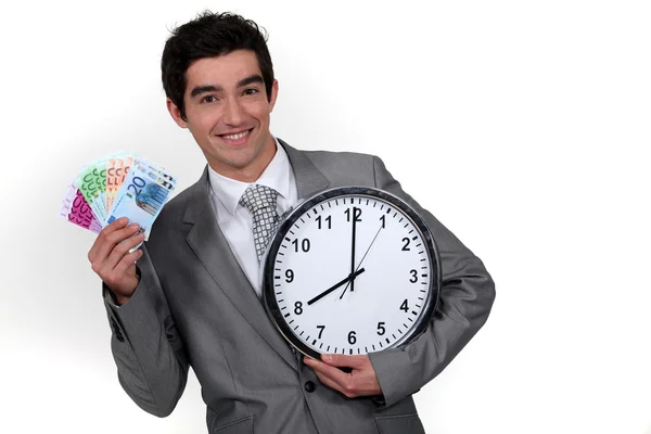 Jeune homme d'affaires avec une liasse d'argent à 8 heures — Photo